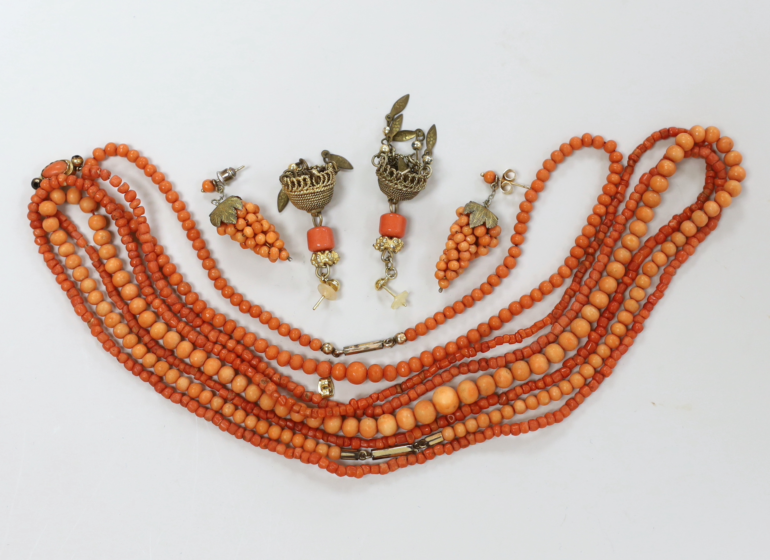 Three coral bead necklaces, largest 110cm and two pairs of earrings including coral cluster modelled as a bunch of grapes.